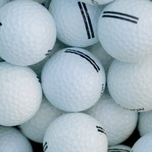 A pile of white golf balls with black stripes.